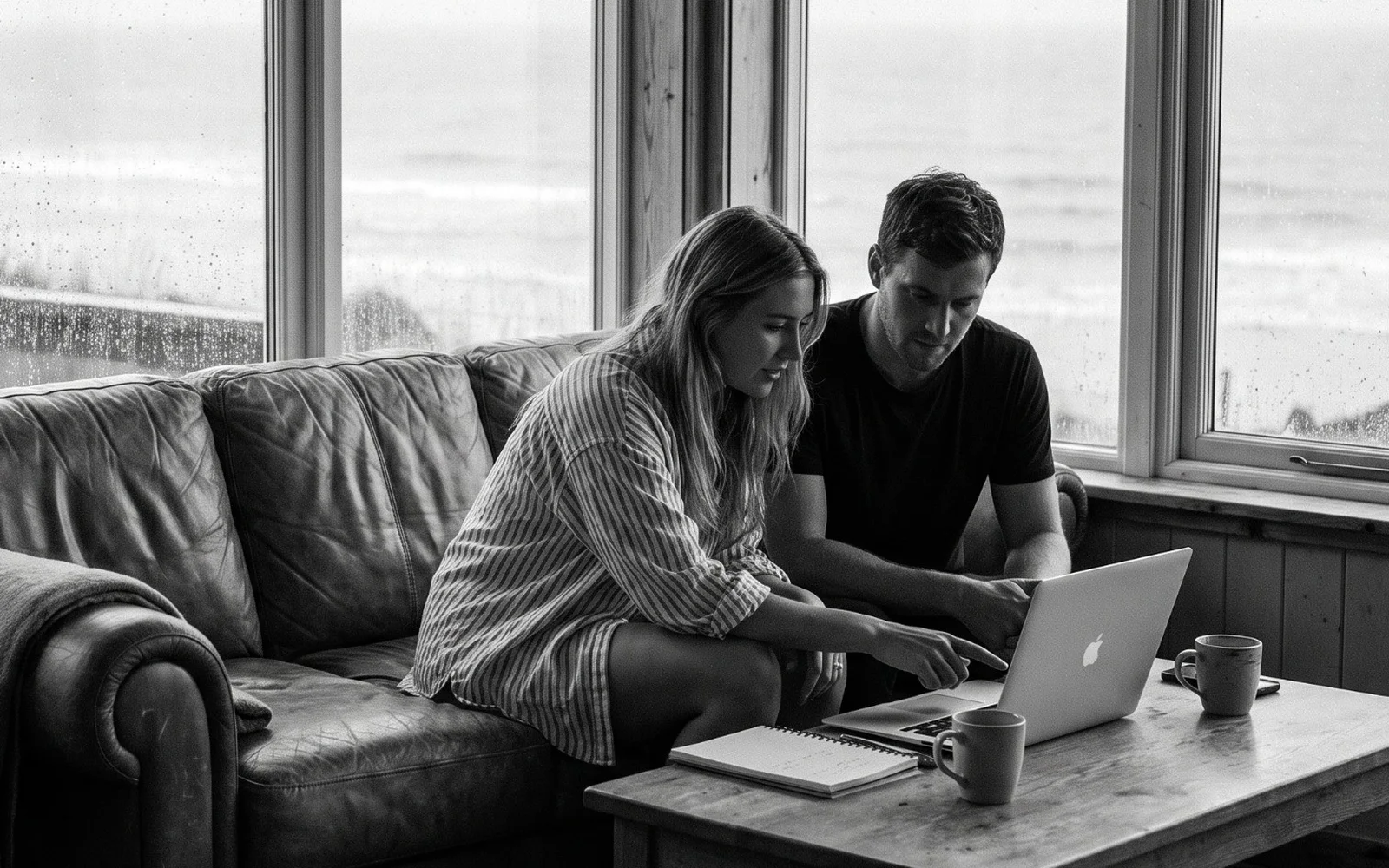 Two founders working on a laptop on a couch by the sea